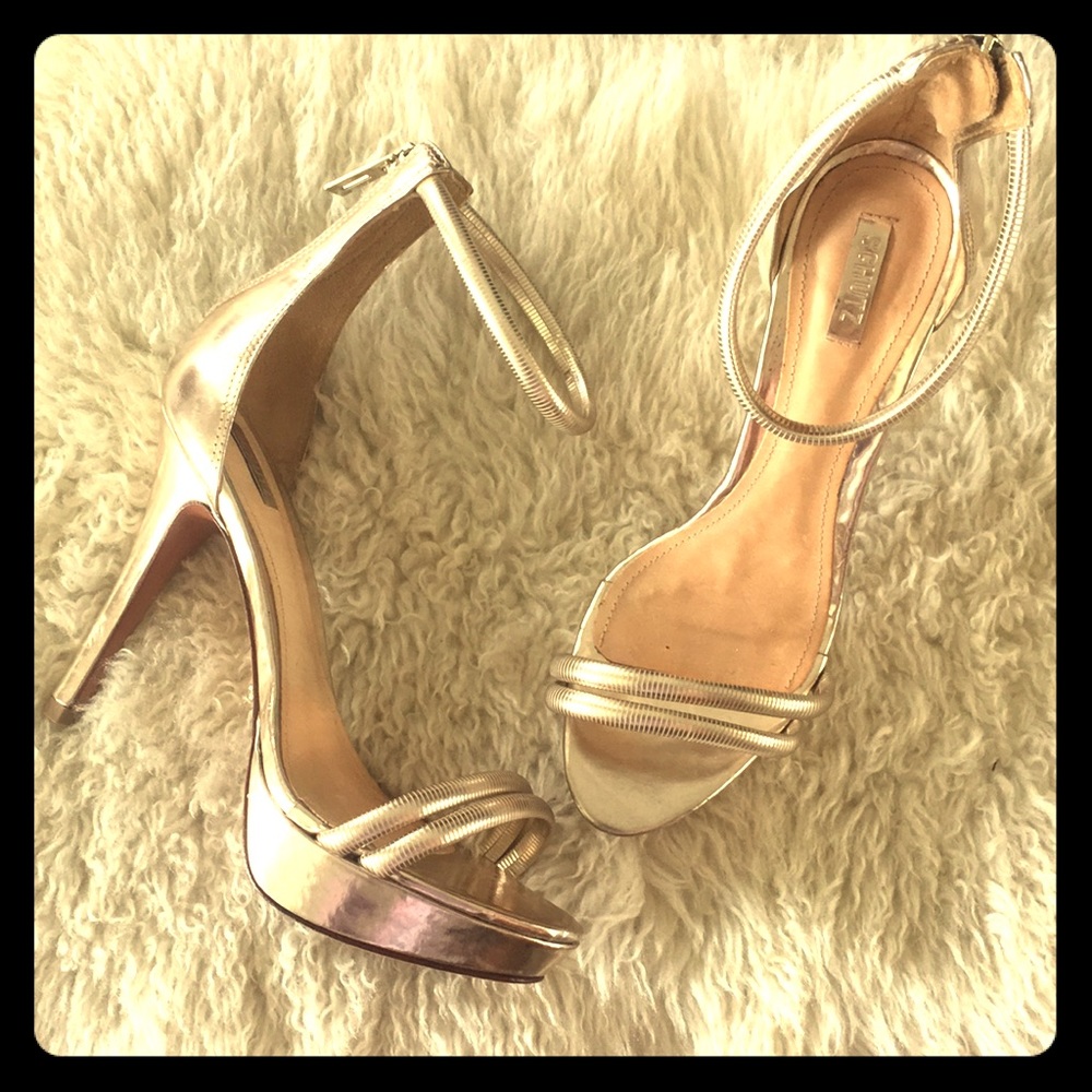 Gold high heel sandals with ankle straps.